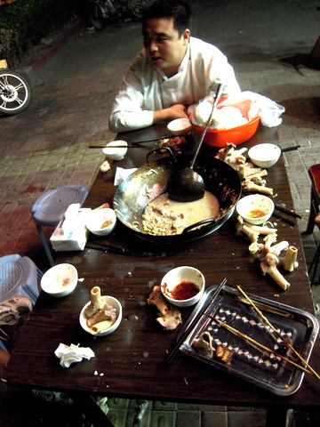 A Chinese table after a meal, littered with liquid and bony debris.